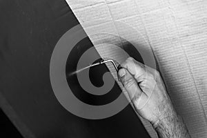 Male hand tightens the screw with a hex wrench in laminated chipboard, furniture assembly