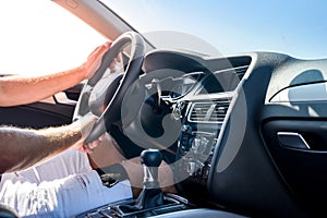 Male hand on transmission gear inside car. Close view of male hand with car interior