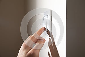 Male hand turning off or on light switch