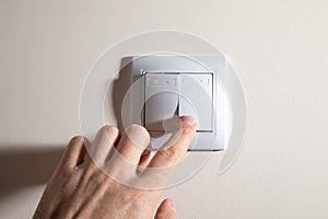 Male hand turning off or on light switch