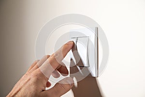 Male hand turning off or on light switch