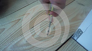 Male hand twist the into a wooden Board using a power screwdriver