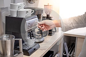 Male hand twisting button on coffee machine