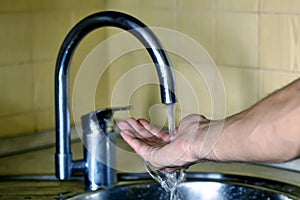 Male hand under running water from the tap. the concept of cleanliness and health. pure water