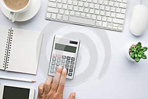 Male hand using calculator on office desk table with copy space