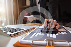 Male hand using calculator and tablet calculate about cost at home office.