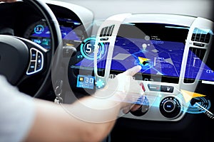 Male hand using navigation system on car dashboard