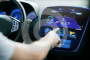 Male hand using navigation system on car dashboard