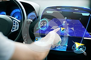 Male hand using navigation system on car dashboard