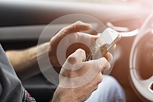 Male hand using smartphone in car. Man driving a car. Smartphone in a car use for Navigate or GPS. Mobile phone in driver hand