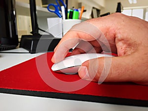 Male hand using a white computer mouse