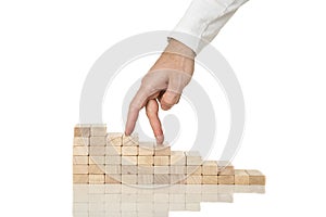 Male hand walking his fingers up wooden staircase made of pegs