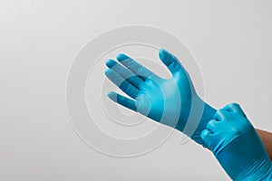 Male hand wearing blue latex gloves, medical, protective, white background