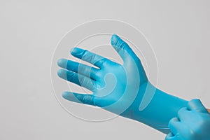 Male hand wearing blue latex gloves, medical, protective, white background