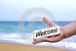 Male Hand with WELCOME signboard