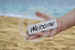 Male Hand with WELCOME signboard