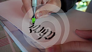 Male hand writes alphabet with ink pen