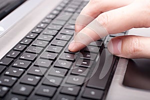 Male hand writing on laptop keyboard