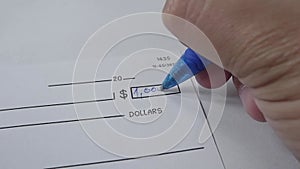 male hand writing money numbers on check.