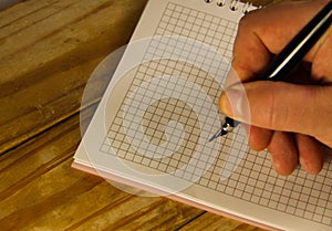 Male hand writing using fountain pen on a notebook