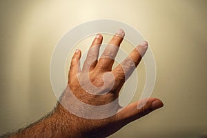 Male hand on a yellowish background