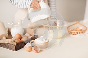 Male hands beating egg whites cream with mixer in the bowl