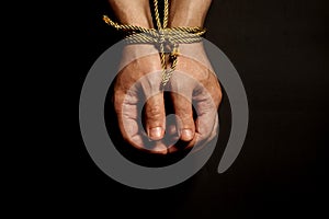 Male hands bound with rope.