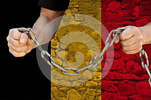 Male hands break the iron chain, a symbol of bondage,protest against the background of the national flag of Belgium, concept of