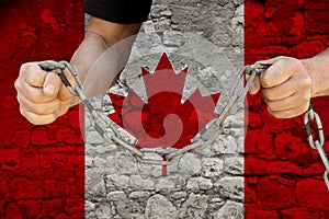 Male hands break the iron chain, a symbol of bondage,protest against the background of the national flag of Canada, the concept of