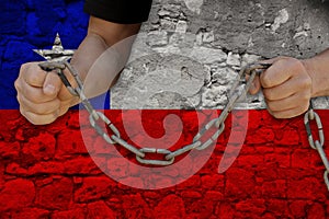 Male hands break the iron chain, a symbol of bondage,protest against the background of the national flag of Chile, concept of