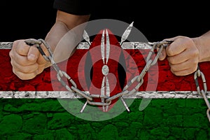 Male hands break the iron chain, a symbol of bondage,protest against the background of the national flag of Kenya, the concept of