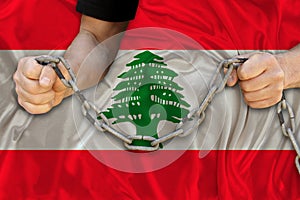 Male hands break the iron chain, a symbol of bondage,protest against the background of national flag Lebanon, concept of political