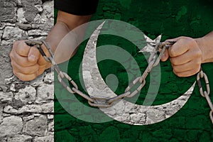 Male hands breaking the iron chain, symbol of bondage, protest against the background of the state flag of Pakistan, the concept