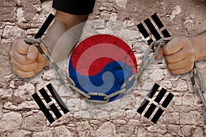 Male hands breaking the iron chain, symbol of bondage, protest against the background of the state flag of South Korea, the