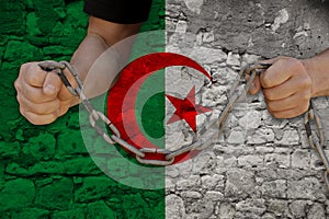 Male hands breaking the iron chain, symbol of tyranny, protest against the background of the state flag of algeria, the concept of