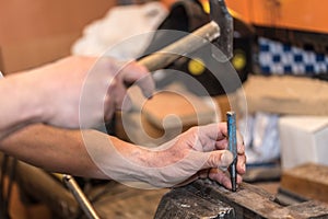 Male hands of builder man holding hammer and scored