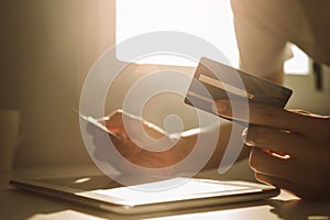 Male hands choosing credit card at working desk for online shopping while break from work at home, E-commerce, Internet banking.