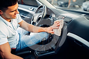 Male hands cleans auto, car dashboard polishing