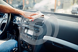 Male hands cleans auto, car dashboard polishing