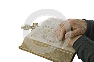 Male hands closed in prayer on an open bible