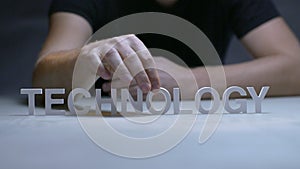 Male hands composition word technology from white letters on gray background