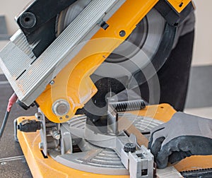 Male hands of  construction worker sawing and cutting parts of  electric miter saw from  wooden board. wood board cutting process