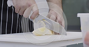 Male hands cutting onion on board at kitchen