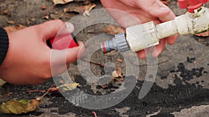 Male hands detach plastic pipes with collet fasteners from each other.