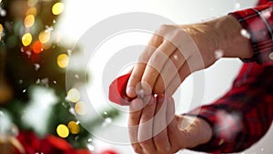 Male hands with diamond ring in christmas gift box