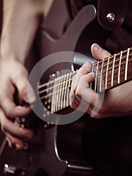 Male hands playing electric guitar