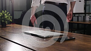 Male hands finishing work at laptop at office desk. Businessman employee leaving after finishing workday, going away