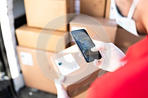 Male hands with gloves taking a picture of a shipping label