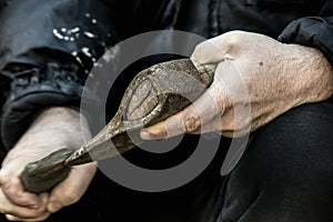 Male hands grinding a hatchet