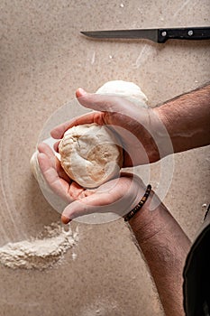 Male hands hold the dough. Human hands prepare dough for home baking. Vertical shot